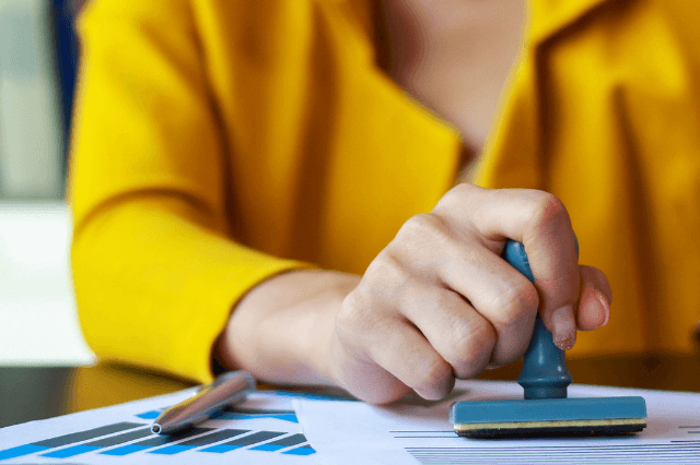 Una traductora pública sellando una traducción en papel.